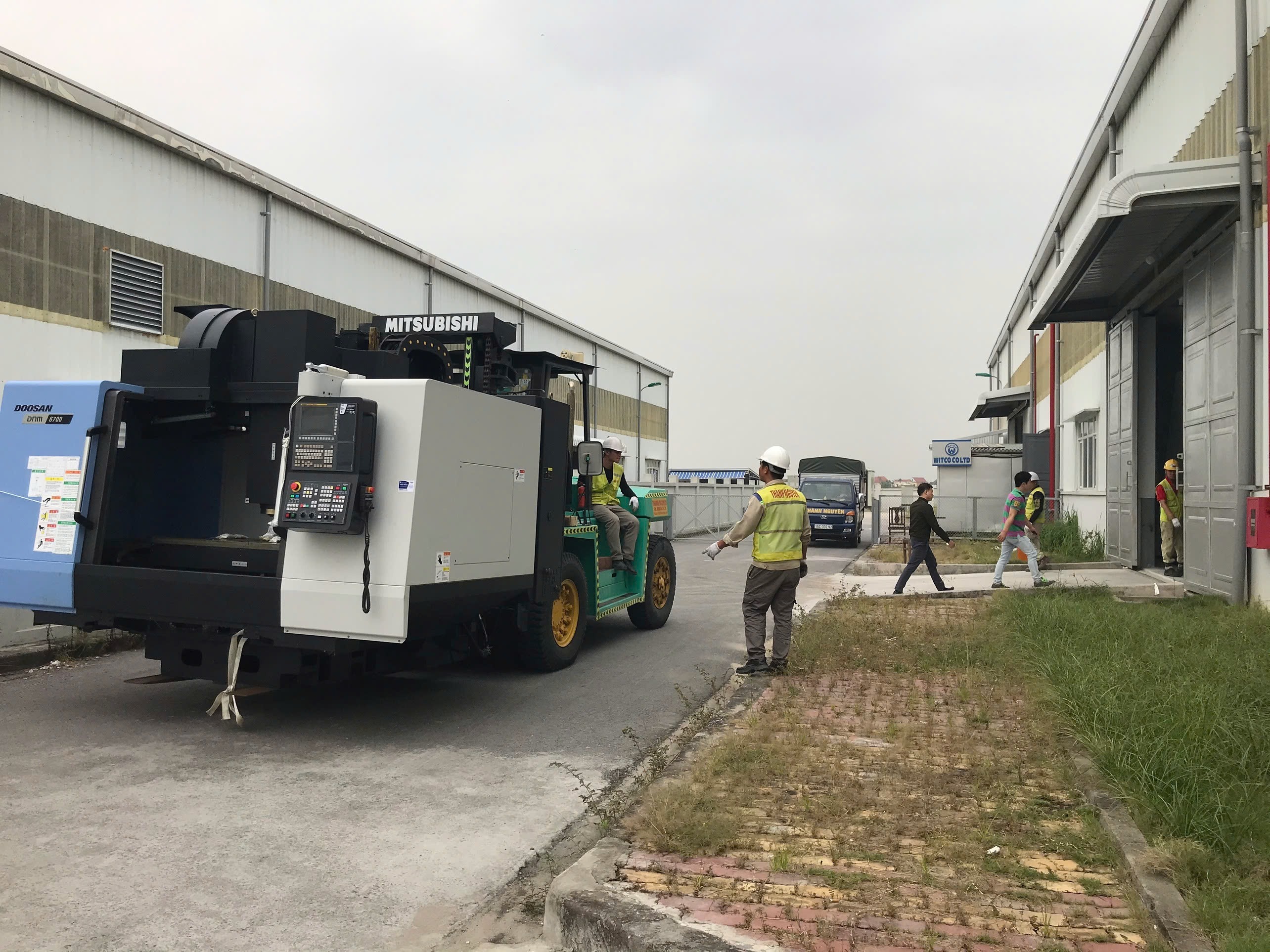 xe nâng Mitsubishi 11.5 tấn luồn càng dài bốc dỡ máy tiện CNC DOOSAN khỏi mooc lùn tại KCN Bỉm Sơn Thanh Hóa 1 - ASIA-APPOLO
